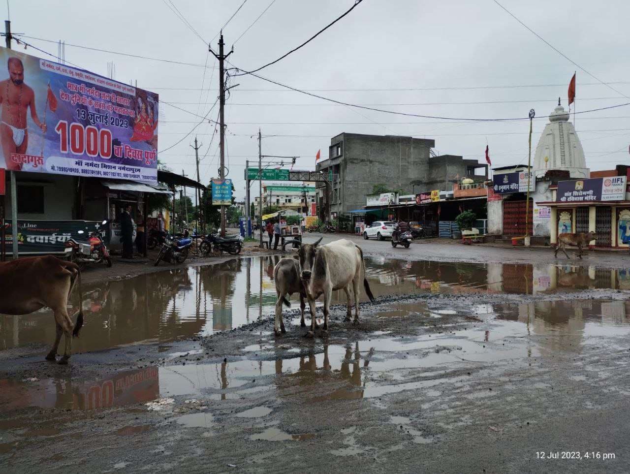 नर्मदा घाट पर जमा हुई मिट्टी सड़कों के गड्ढों में भराया बारिश का पानी